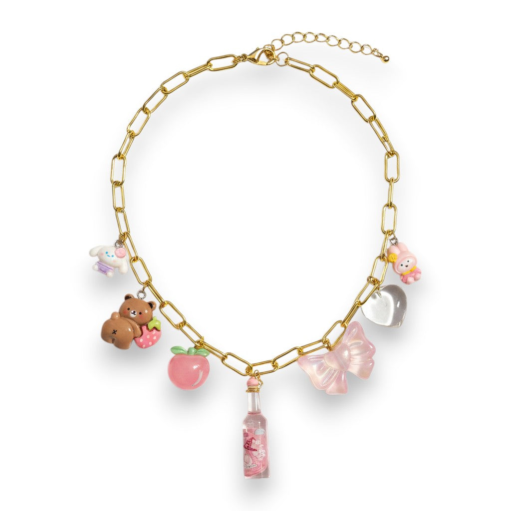 Pretty Gorgeous Stuff pink candy charm necklace with gold chain, featuring bear, bow, and bottle charms.